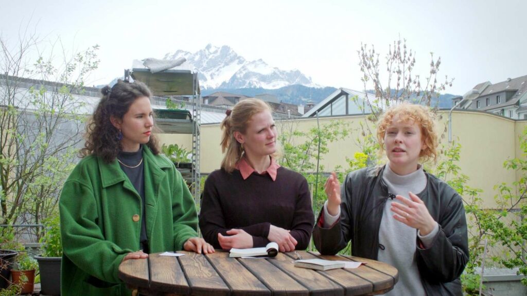 Gianna Rovere, Stefanie Julia Janssen, Isabelle Weber frontal stehend vor einem runden Holztisch
